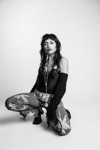 a black and white photo of a woman crouching down